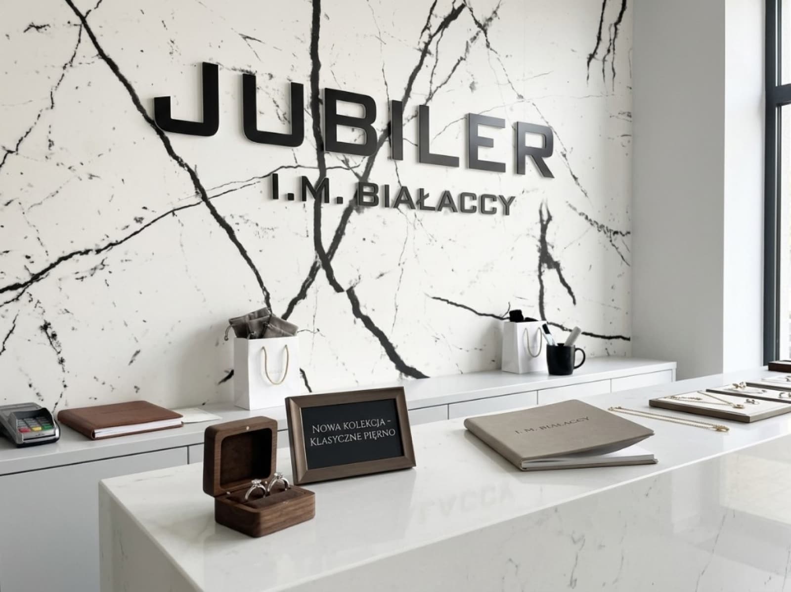 Wnętrze salonu jubilerskiego I.M. Białaccy z marmurową ścianą i logo